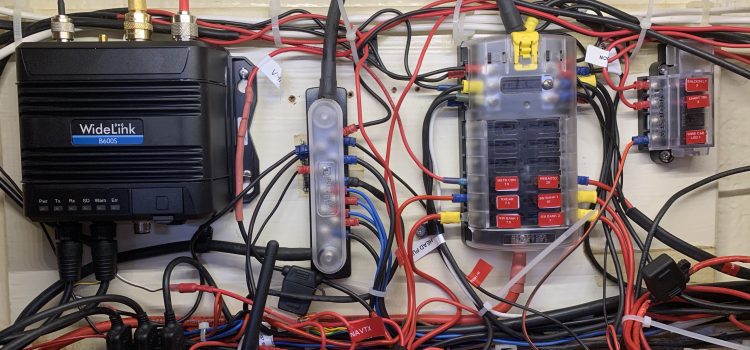 Wiring in the B600s – Saturday A photo of all the wiring in the wiring locker on Blue Opal; square-on view showing the AIS, multiplexer, bus bars, and fuse blocks